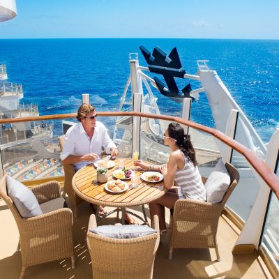 AL, Allure of the Seas, couple having lunch in balcony in AquaTheater Suite, ocean horizon in background, wicker table and chairs, blue sea, relaxing, enjoyment